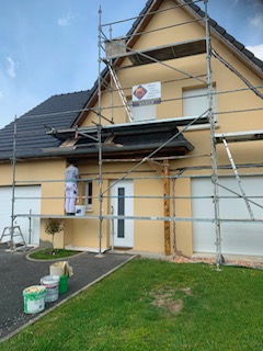 Travaux de façade sur une maison individuelle sous échafaudage